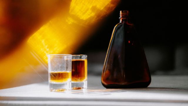 Flacon de liqueur ambrée et deux petits verres Flacon de liqueur ambrée et deux petits verres