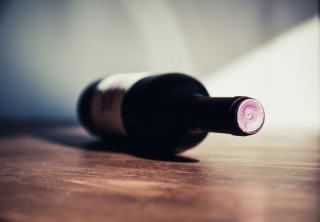 Bouteille de vin rouge couchée sur une table en bois