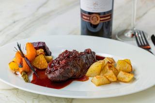 Viande grillée servie avec une bouteille de vin rouge